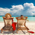Couple in loungers on beach at Maldives